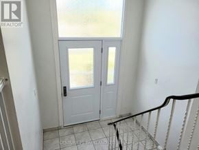 Brampton (Brampton North) apartment for rent - A white door with a glass window is in a room with a tiled floor.