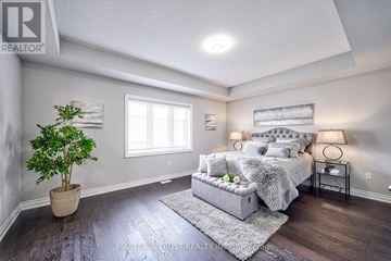 Burlington (Alton) apartment for rent - A bedroom with a large bed and a potted plant.