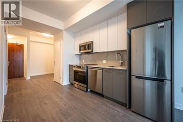 Kitchener condo for rent - A modern kitchen with stainless steel appliances and wooden flooring.