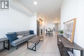 Vaughan (Brownridge) condo for rent - A living room with a grey couch and a wooden table.