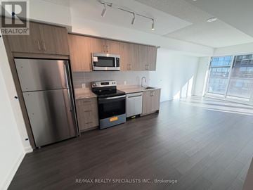 Toronto (Humber Heights) condo for rent - A kitchen with a stainless steel refrigerator and microwave above the stove.