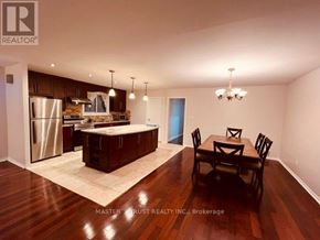 Toronto (Hillcrest Village) apartment for rent - A well-lit kitchen with dark wood floors and a dining table set for four.