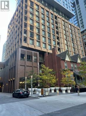 Toronto (Waterfront Communities) condo for rent - A tall building with a car parked in front of it.