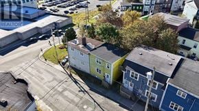 St. John's apartment for rent - A bird's eye view of a street with houses on the right and a parking lot on the left.