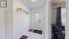 St. John's apartment for rent - A hallway with a white door and a black and white patterned chair.
