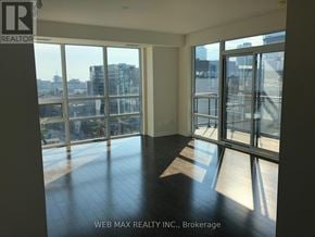 Toronto (Moss Park) condo for rent - A room with a view of the city through large windows.