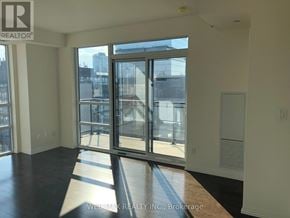 Toronto (Moss Park) condo for rent - A room with a large window and a view of the city.