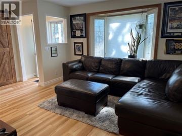 Sarnia apartment for rent - A living room with a black leather couch and ottoman.