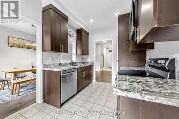 Vaughan (Maple) townhouse for rent - A modern kitchen with dark wood cabinets and a marble countertop.