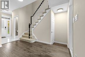 Vaughan (Maple) townhouse for rent - A staircase with a black railing and wooden steps leads up to a white door.
