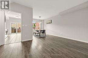 Vaughan (Maple) townhouse for rent - A spacious room with wooden flooring and white walls, furnished with a dining table and chairs.