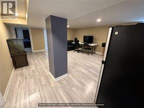 Hamilton apartment for rent - A room with a desk, chairs, and a television.