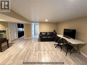 Hamilton apartment for rent - A living room with a black leather couch, a white table, and a television.