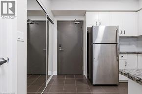 Guelph condo for rent - A kitchen with a refrigerator, two doors, and a counter.