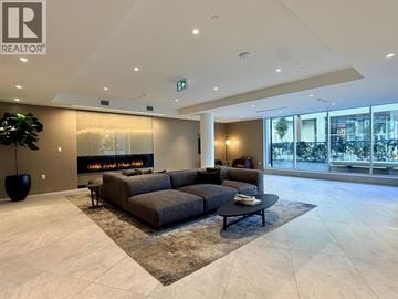 North Vancouver apartment for rent - A modern living room with a large grey sofa and a fireplace.