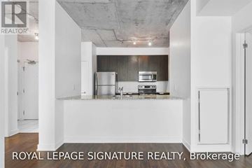 Toronto (Waterfront Communities) condo for rent - A kitchen with white cabinets and a stainless steel refrigerator.