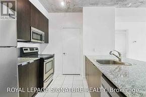 Toronto (Waterfront Communities) condo for rent - A kitchen with a refrigerator, microwave, oven and sink.
