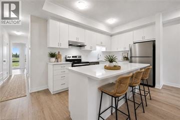 Kitchener townhouse for rent - A modern kitchen with white cabinets and a central island.