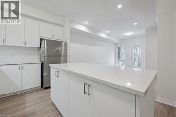 Kitchener townhouse for rent - A white kitchen with a refrigerator and cabinets.