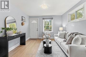 London East (East H) apartment for rent - A well-lit living room with a grey couch and a black console table.