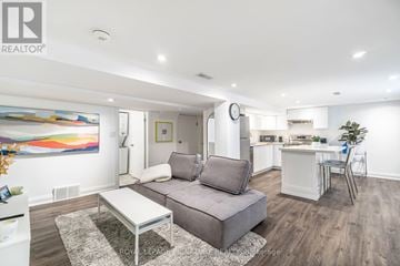 Toronto (Clairlea-Birchmount) apartment for rent - A modern living room with a grey sofa and a glass coffee table.