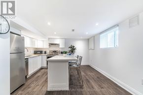 Toronto (Clairlea-Birchmount) apartment for rent - A kitchen with a refrigerator, sink, and a dining table with chairs.