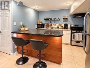 Toronto (Centennial Scarborough) apartment for rent - A kitchen with a bar stool and a counter.
