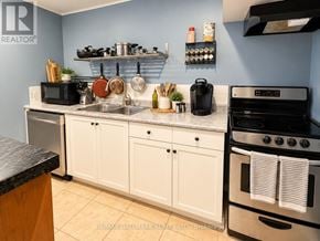 Toronto (Centennial Scarborough) apartment for rent - A kitchen with white cabinets and a black stove top oven.