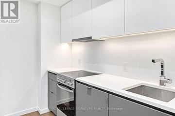 Toronto (Stonegate-Queensway) condo for rent - A white kitchen with a sink and a stove top oven.