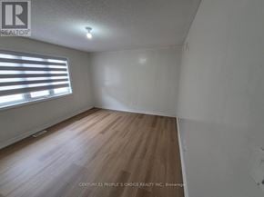 Brampton (Bram East) apartment for rent - A room with wooden flooring and a window with blinds.