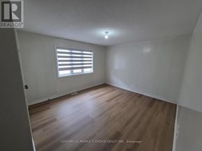 Brampton (Bram East) apartment for rent - A room with wooden flooring and a window with blinds.