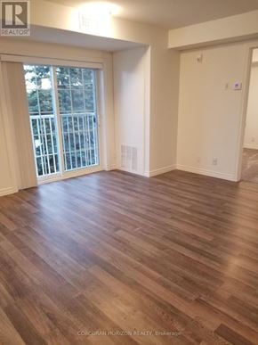 Tillsonburg house for rent - A room with wooden flooring and a sliding glass door leading to a balcony.