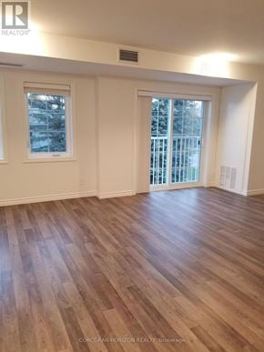 Tillsonburg house for rent - A room with wooden flooring and two windows.