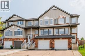 Kitchener townhouse for rent - A large, two-story house with a garage and a driveway.