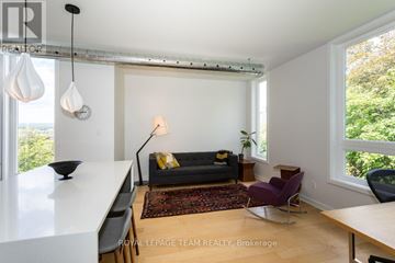 Ottawa condo for rent - A living room with a black couch and a white table.