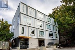 Ottawa condo for rent - A modern building with a glass facade and a sign that reads "Royal LePage RE/MAX".