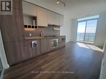 Vaughan (Vaughan Corporate Centre) condo for rent - A kitchen with wooden cabinets and a large window overlooking the ocean.