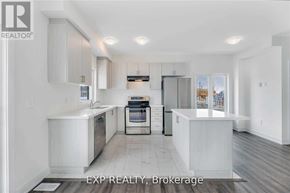 Barrie (Painswick South) townhouse for rent - A white kitchen with a sink, stove, and refrigerator.