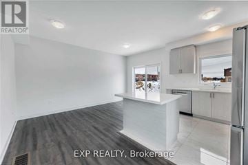 Barrie (Painswick South) townhouse for rent - A kitchen with white cabinets and a refrigerator.