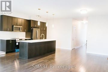 Milton (Wi Willmott) townhouse for rent - A modern kitchen with dark brown cabinets and a white island.