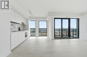 Toronto (Thorncliffe Park) condo for rent - A spacious, empty room with a view of the cityscape through large windows.