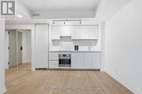 Toronto (Thorncliffe Park) condo for rent - A white kitchen with a wooden floor and a white ceiling.