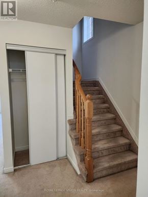 Innisfil (Alcona) townhouse for rent - A staircase with wooden balusters and a carpeted floor.