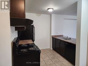 Innisfil (Alcona) townhouse for rent - A black stove in a kitchen with a sink and cabinets.