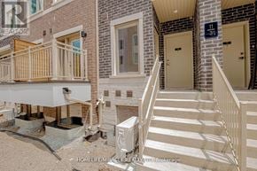 Vaughan (Vaughan Corporate Centre) townhouse for rent - A building with a balcony and stairs leading to the door.