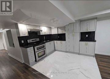 Vaughan (Vellore Village) apartment for rent - A modern kitchen with white cabinets and black countertops.