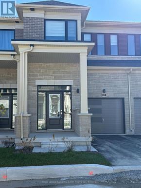 Kawartha Lakes (Lindsay) townhouse for rent - A house with a grey garage door and a black door.