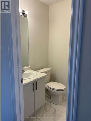 Kawartha Lakes (Lindsay) townhouse for rent - A white toilet sits next to a sink in a bathroom.