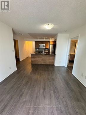 Toronto (Niagara) condo for rent - A spacious living room with wood flooring and a television.