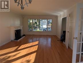 St. John's apartment for rent - A large empty room with wooden floors and a fireplace.